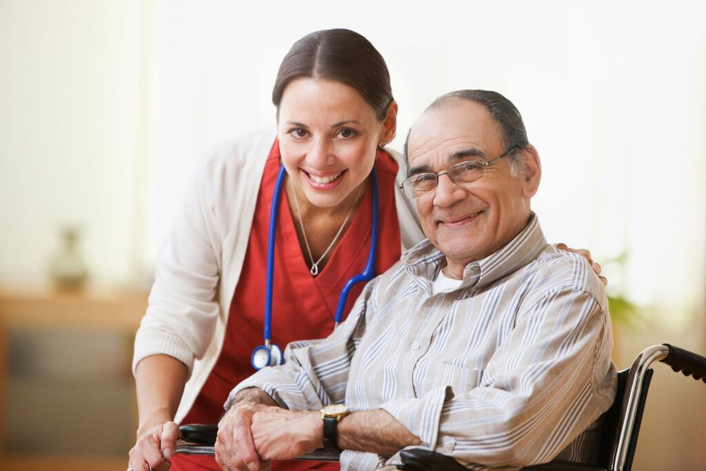 A senior man poses for a picture with a nurse.