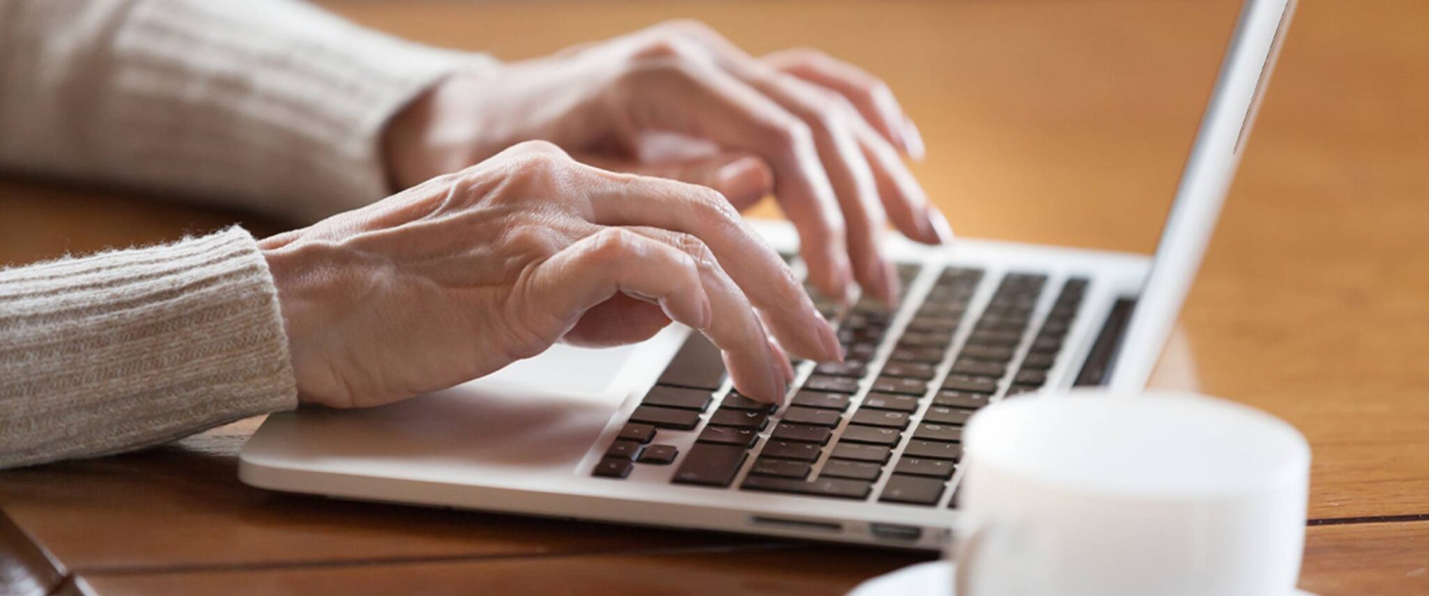 senior typing on a laptop in a senior home