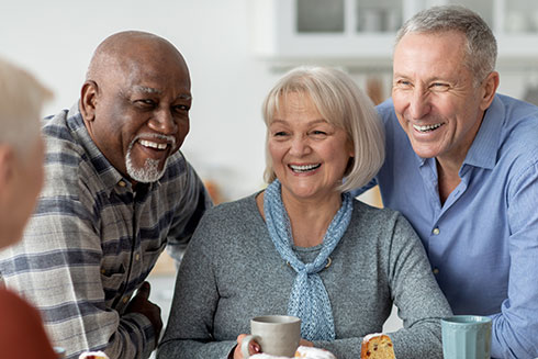 Seniors chat and laugh over coffee.