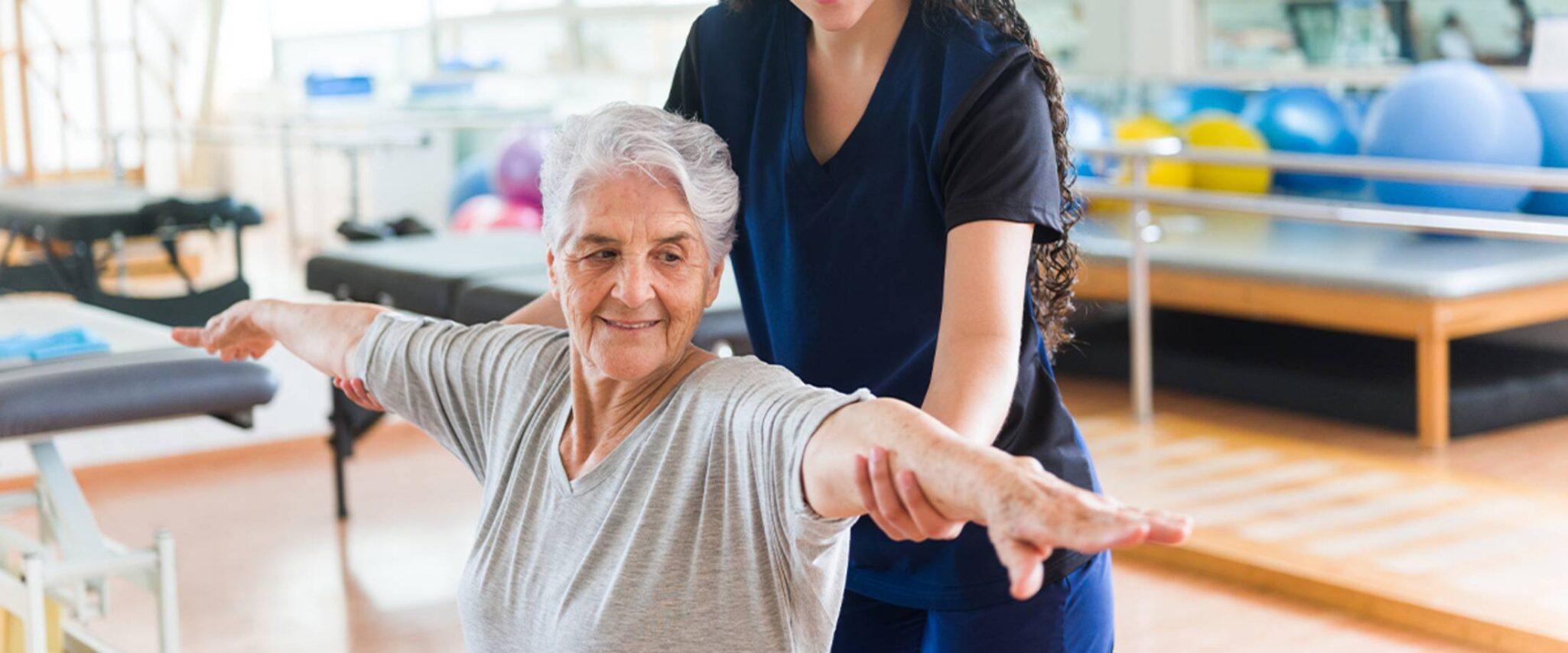elderly woman doing exercises with the help of a physical therapist