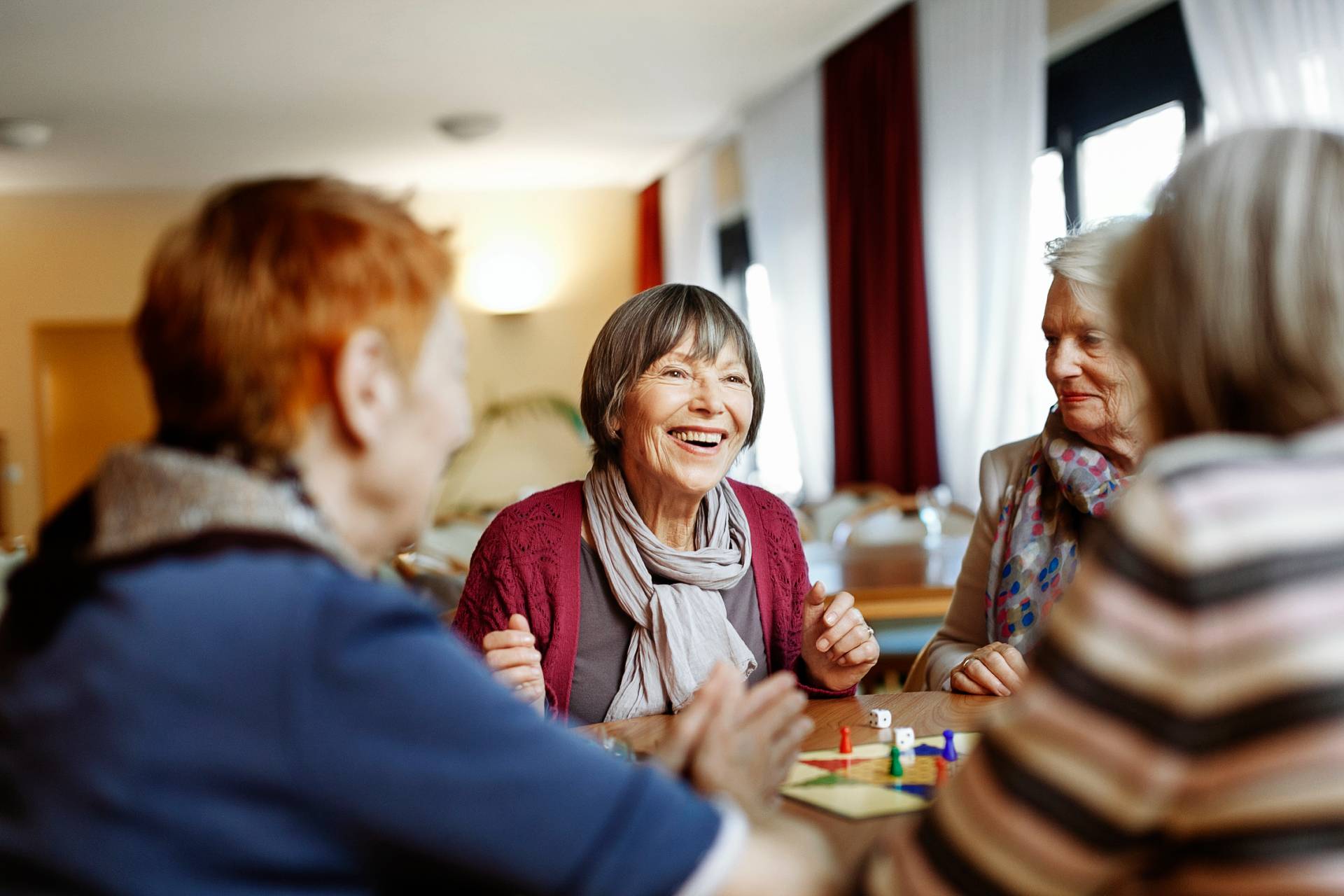 happy senior ladies enjoying morning coffee together at a kitchen table