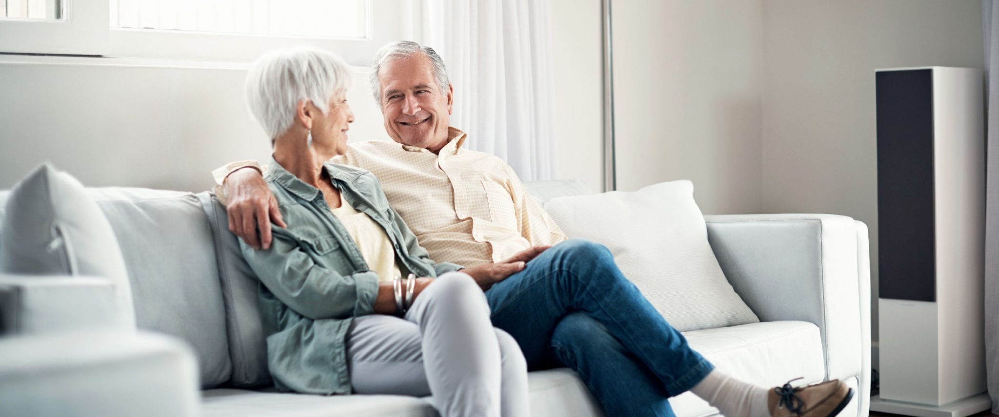 senior couple sitting on a couch in their senior living community