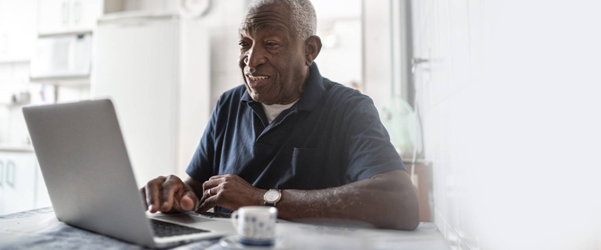 elderly man browsing the web on his laptop