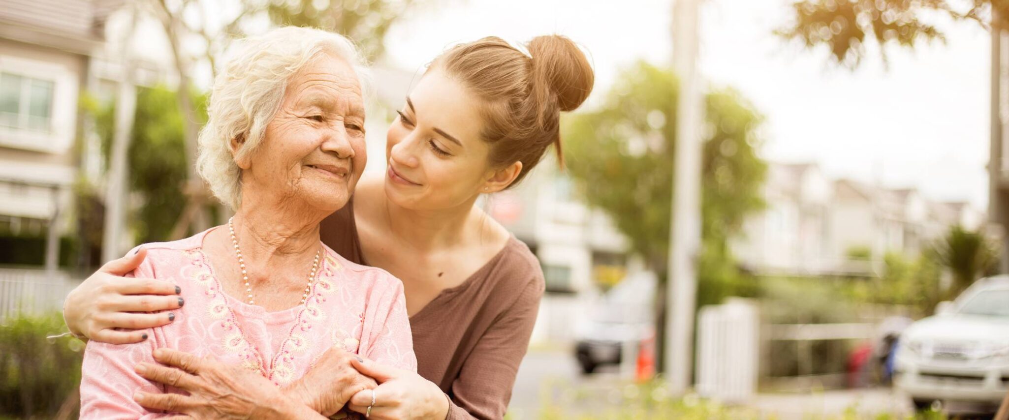 a senior with her granddaughter with their arms wrapped around each other