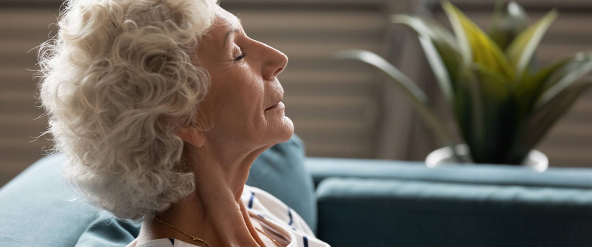 Senior woman relaxing with her eyes closed on a couch