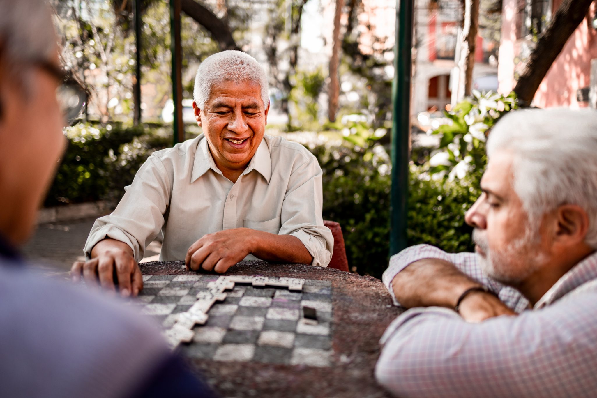 Group of senior friends playing dominoes outside